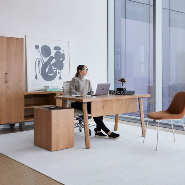 Person sitting in office with wood furniture