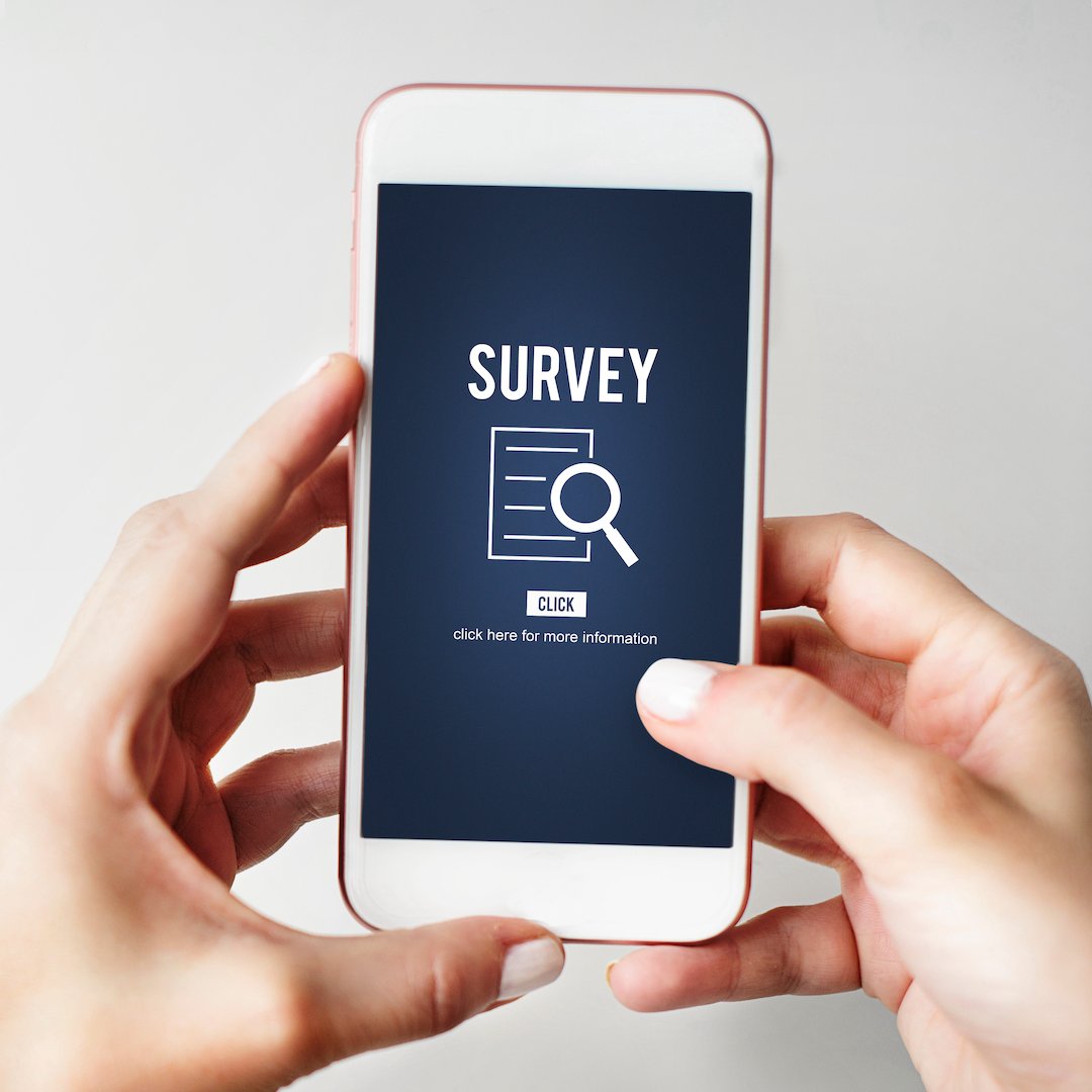 Person holding a mobile phone taking an online survey